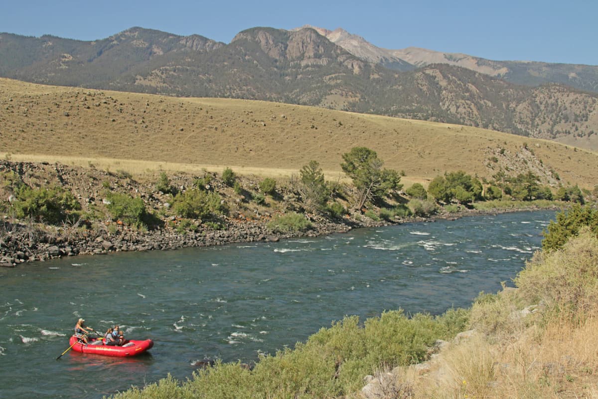 Group rafting on a Class II section of the Yellowstone River, in a red raft